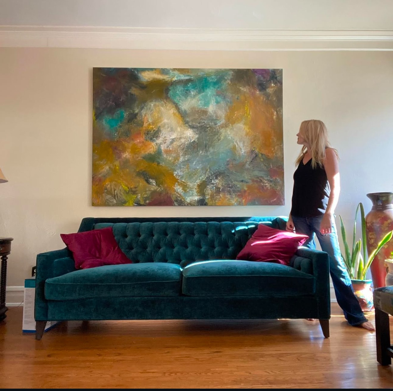 Abstract painting above teal sofa