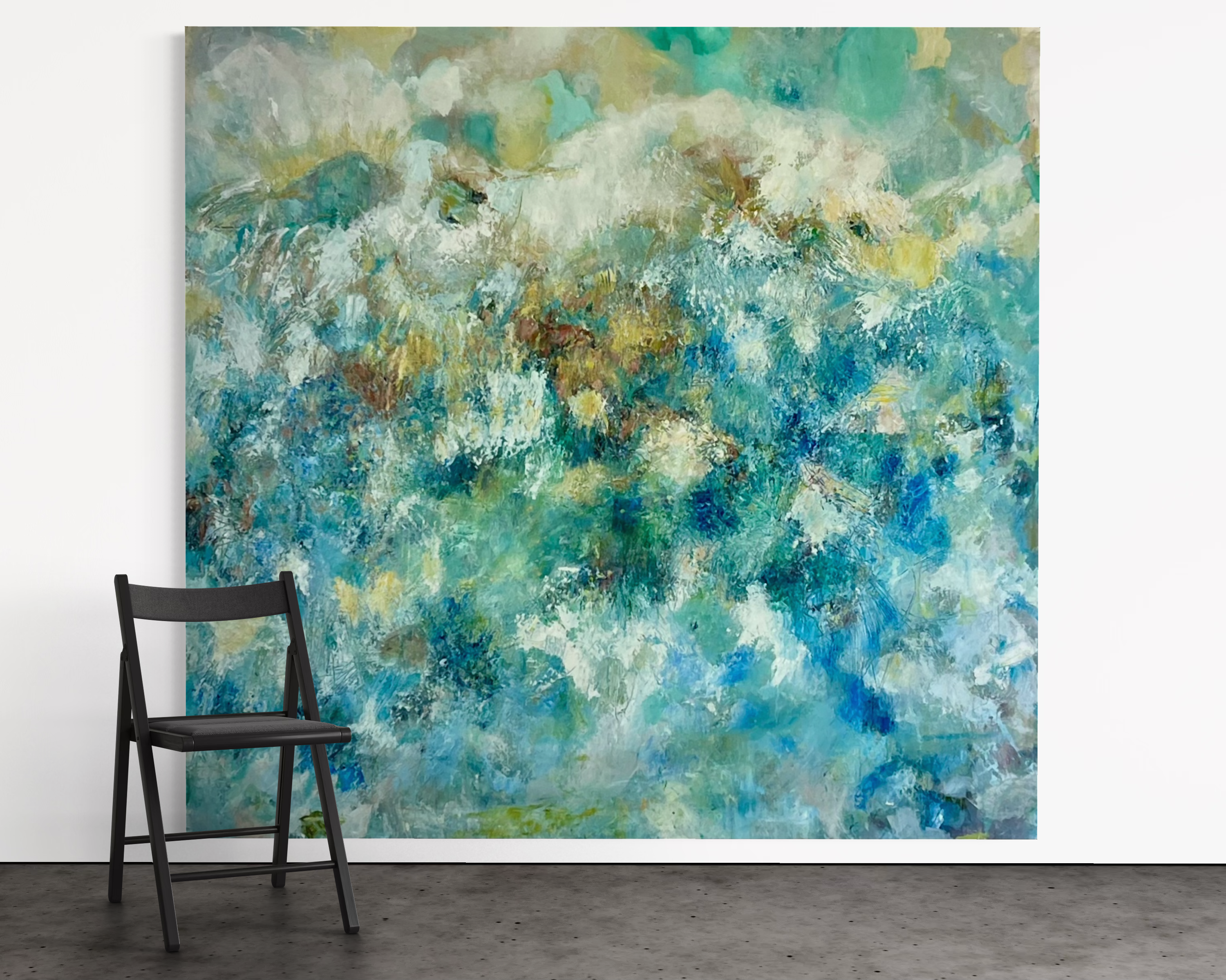 Large abstract painting in teal, blue, green and gold tones leaning against white gallery wall beside black folding chair